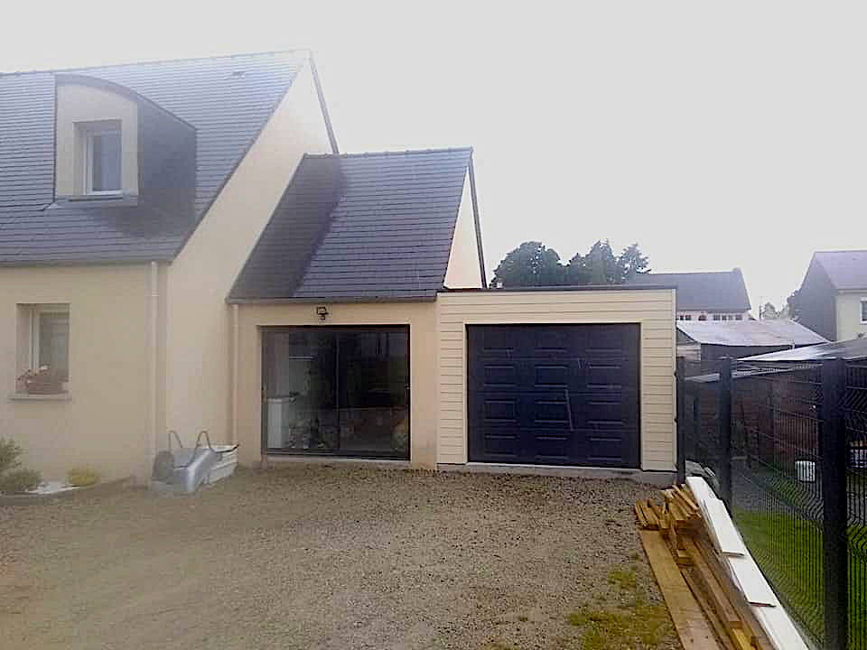 Extension en bois avec bardage terminé et porte de garage installée. Couverture Delalande, expert en extensions et bardages à Vieux-Viel.